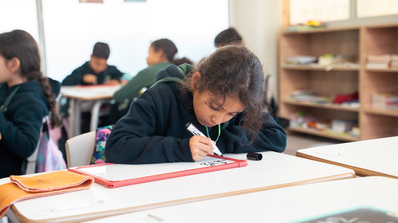 Élèves de l’école portant leurs uniformes, assis dans une salle de classe lumineuse